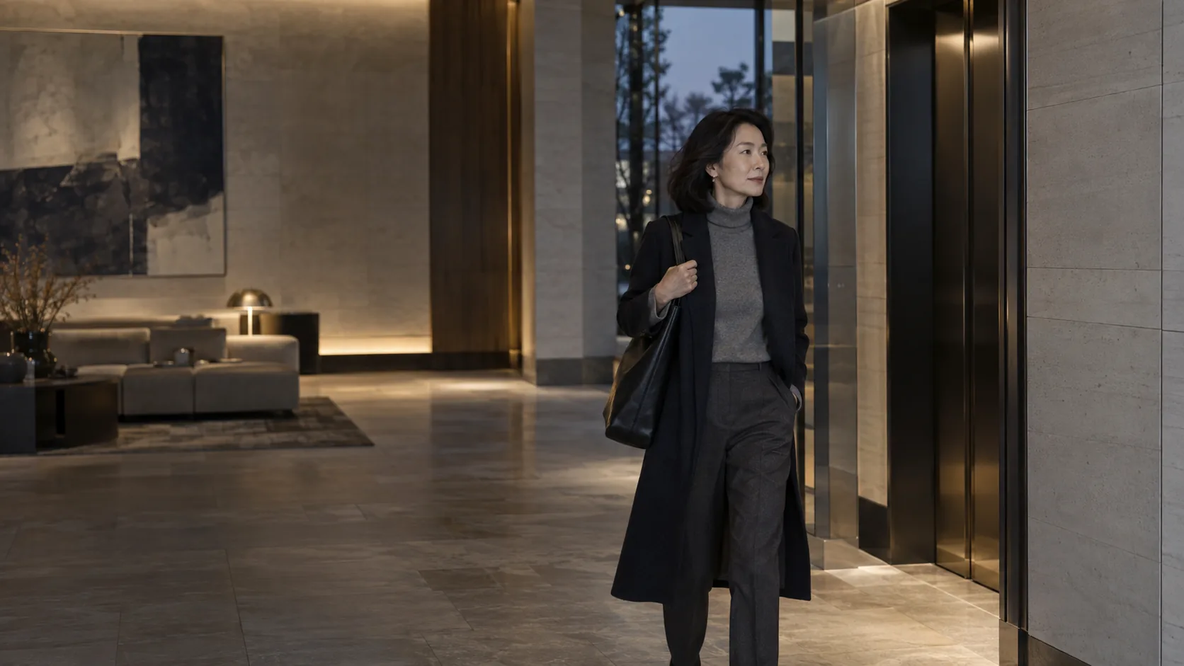 A resident walks through an elegant residential lobby toward the elevators.